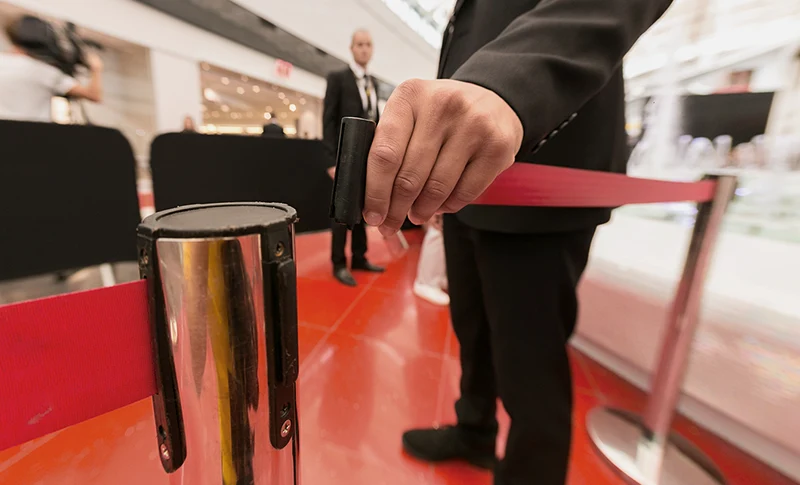 Un garde se tient à l'entrée d'un évènement derrière la barrière