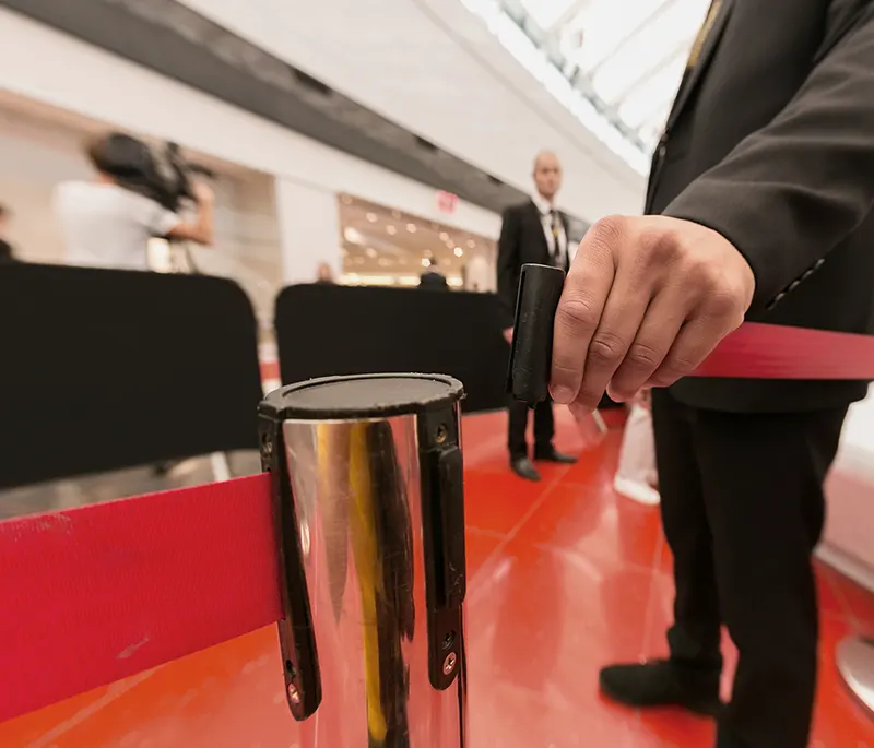 Un garde se tient à l'entrée d'un évènement derrière la barrière